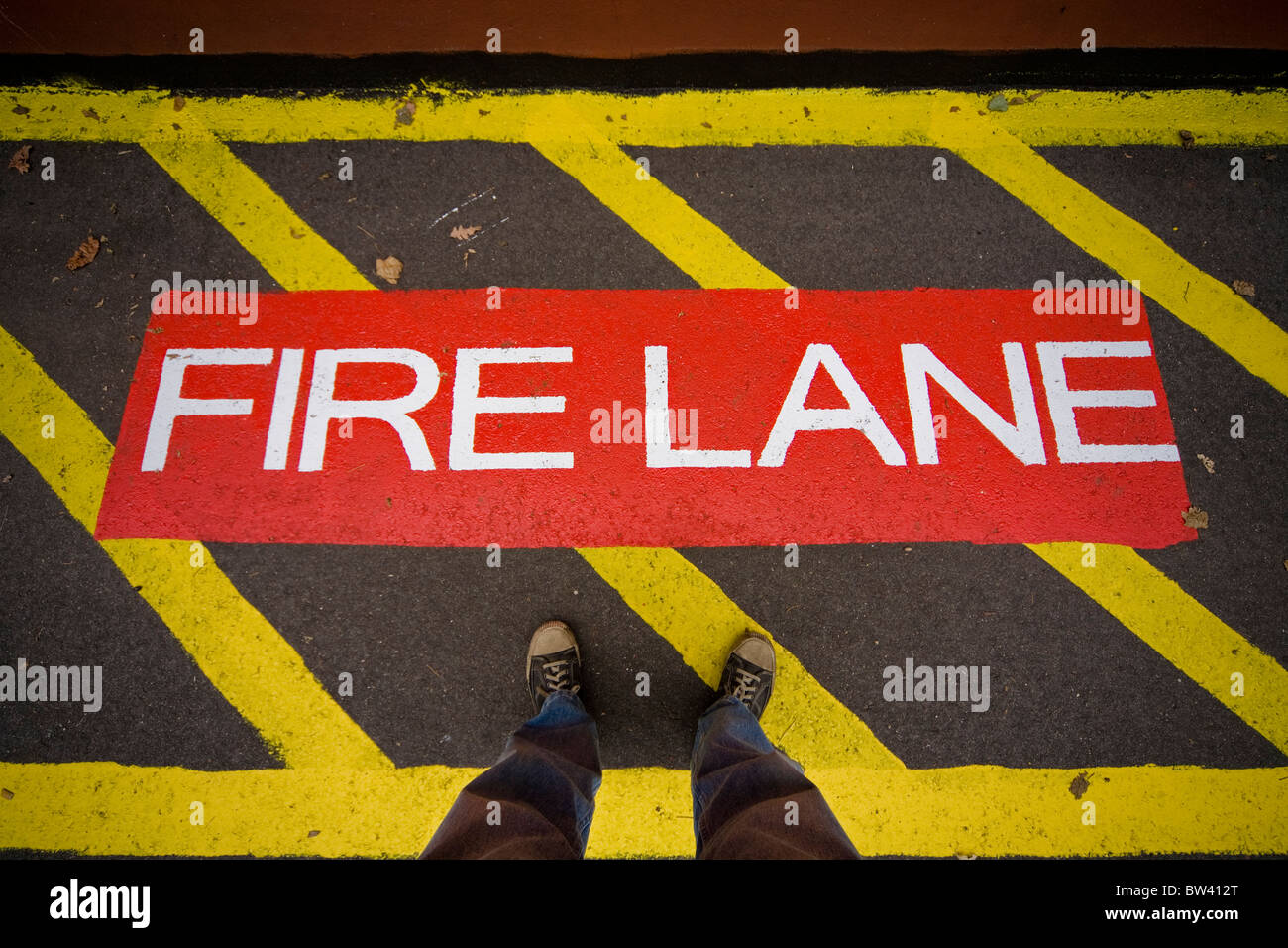 Mann stand in einem Abschnitt einer Auffahrt mit der Aufschrift "Fire Lane" Stockfoto