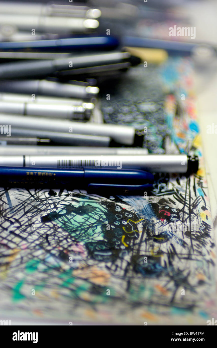 Marker und Pens lag oben auf ein Papier mit Kritzeleien auf den Arbeitsbereich als Comiczeichner bedeckt. Stockfoto