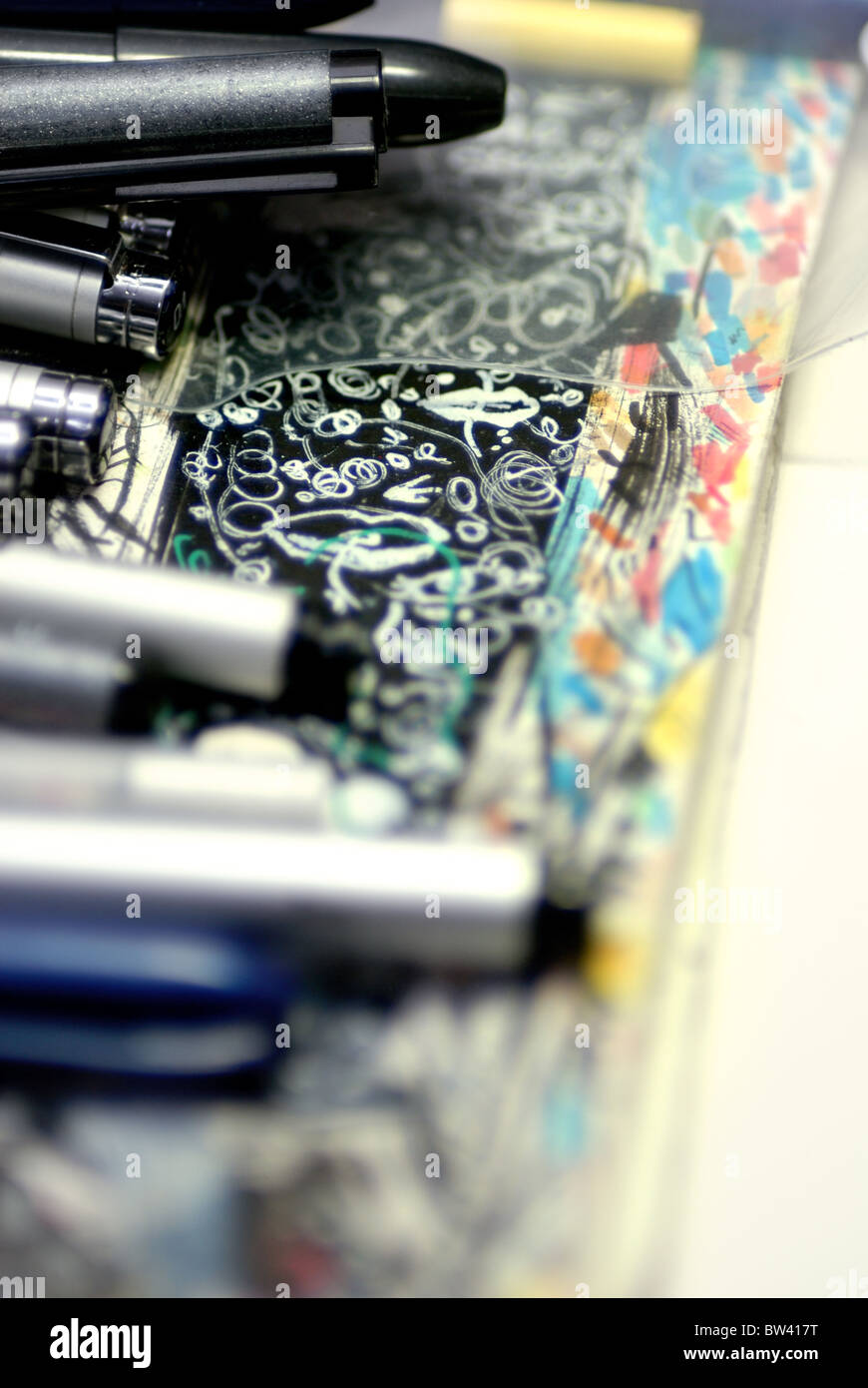 Marker und Pens lag oben auf ein Papier mit Kritzeleien auf den Arbeitsbereich als Comiczeichner bedeckt. Stockfoto