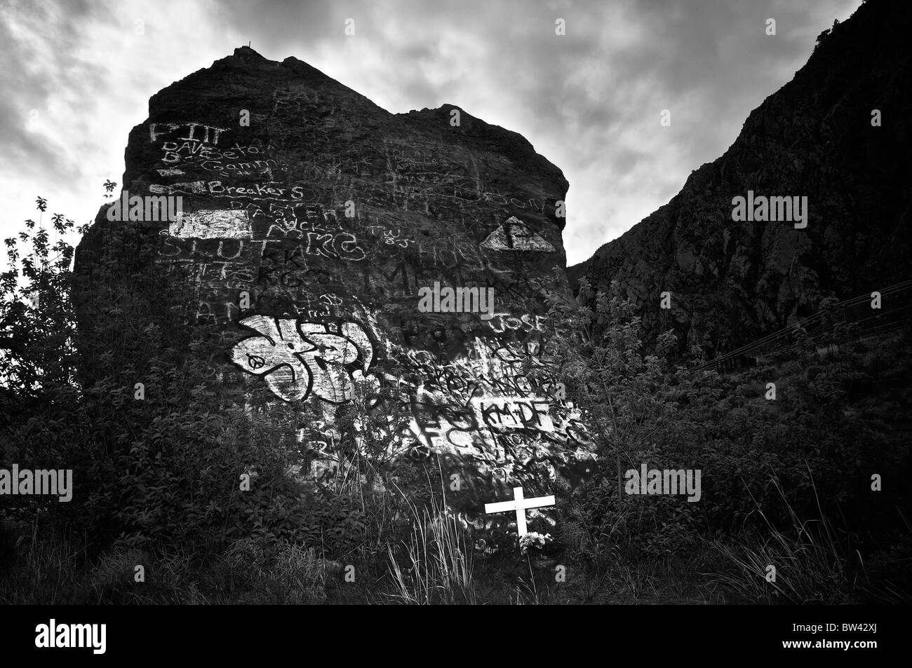 Am Straßenrand weißes Kreuz gegen große Graffiti gefüllt Rock, Route 3, Britisch-Kolumbien, Kanada Stockfoto