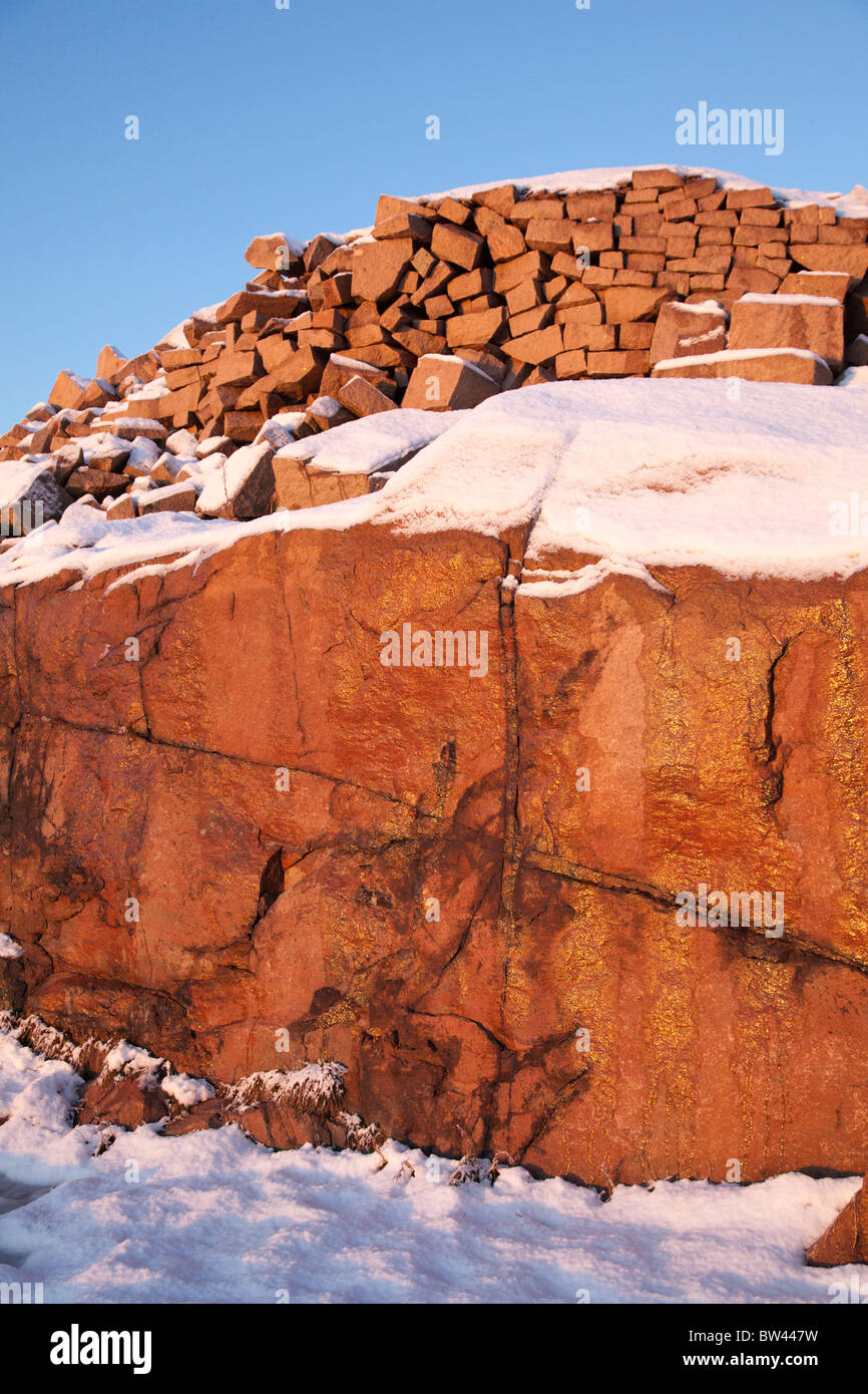 Roter Granit im Schnee, Abendlicht beleuchtet. Stockfoto