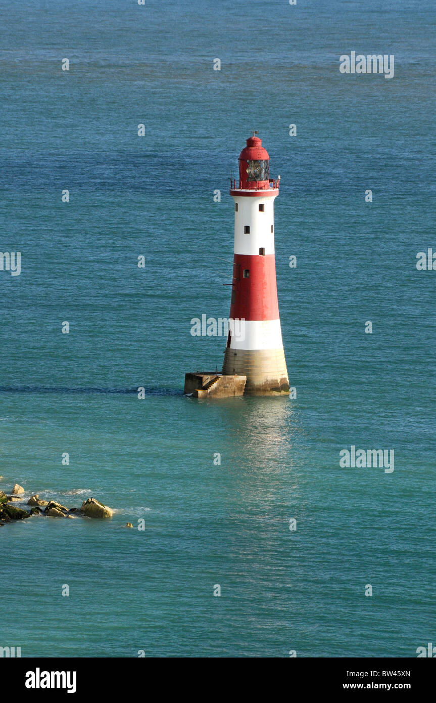 Eine rot-weiße Leuchtturm umgeben mit ruhigem Wasser tagsüber Stockfoto