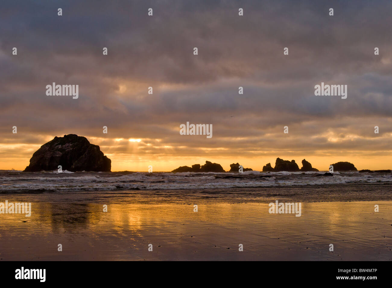 Rock und stürmischen Sonnenuntergang, Bandon Strand, südliche Oregon Küste konfrontiert. Stockfoto