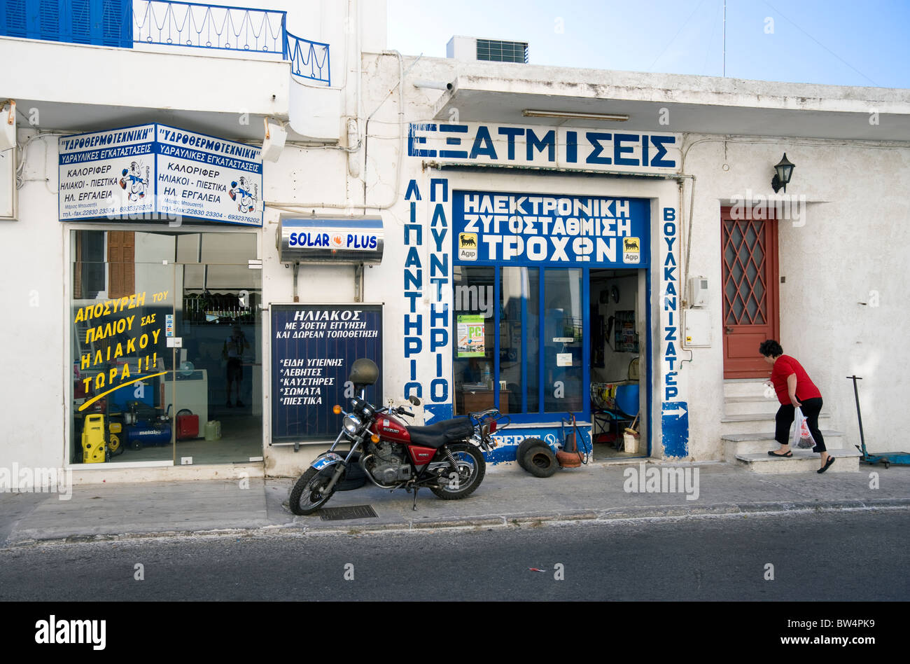 Frau in ihrem Haus an einer Einkaufsstraße von Tinos-Stadt auf der griechischen Kykladen Insel Tinos Stockfoto
