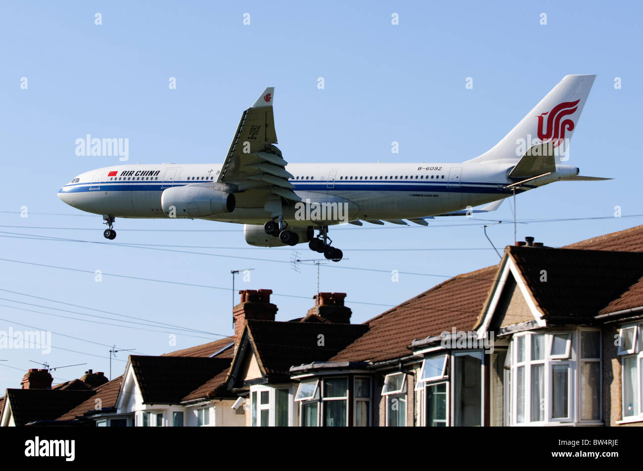 Airbus A330 von Air China auf Ansatz für die Landung in London Heathrow Flughafen, Großbritannien, niedrig über Myrtle Avenue Häuser. Stockfoto