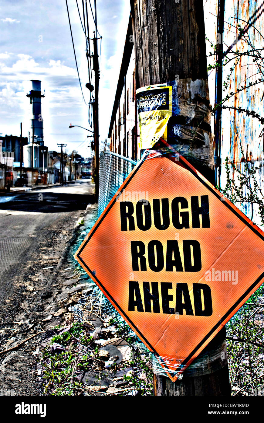 Ominöse über exponierte Zeichen auf eine industrielle Straße in kontrastreichen gesättigt-Stil, der die Metapher "Rough Road Ahead" hinzufügt Stockfoto