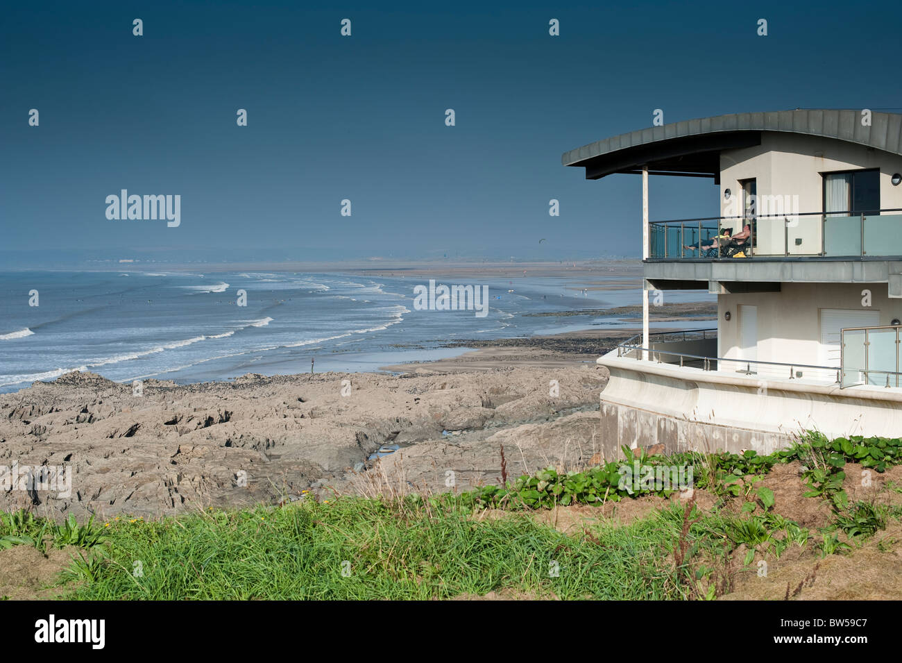 Zwei Personen nehmen Sie ein Sonnenbad im modernen Apartments an Küste, Westward Ho! Devon UK Stockfoto