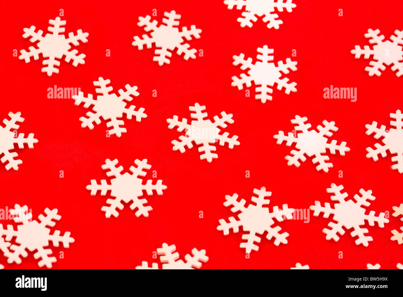 Hintergrund der weißen Schneeflocken über rot Stockfoto