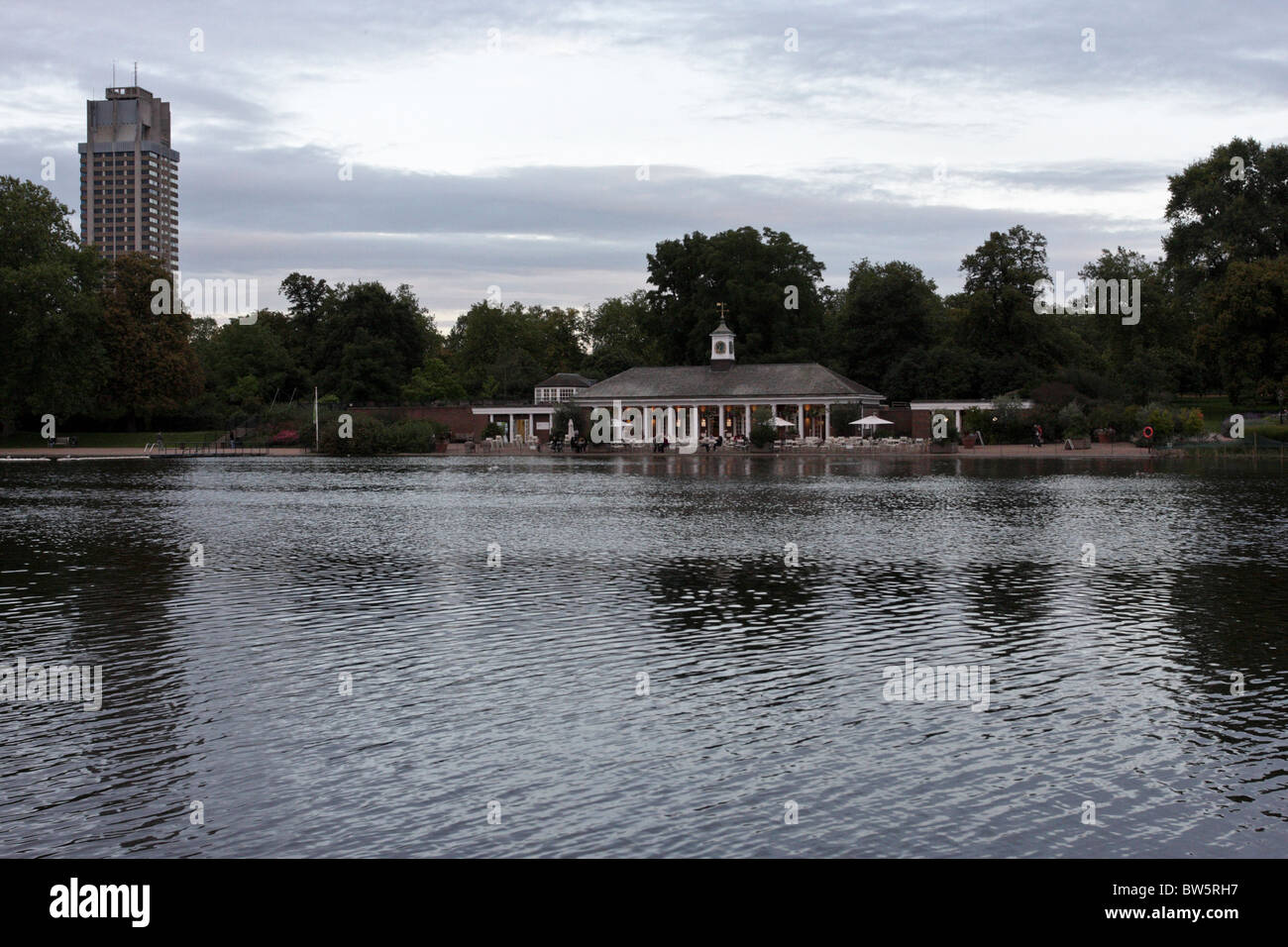 Das Hochhaus der Knightsbridge-Kaserne in der Ferne, Heimat der Household Cavalry, die Serpentine Restaurant am See. Stockfoto