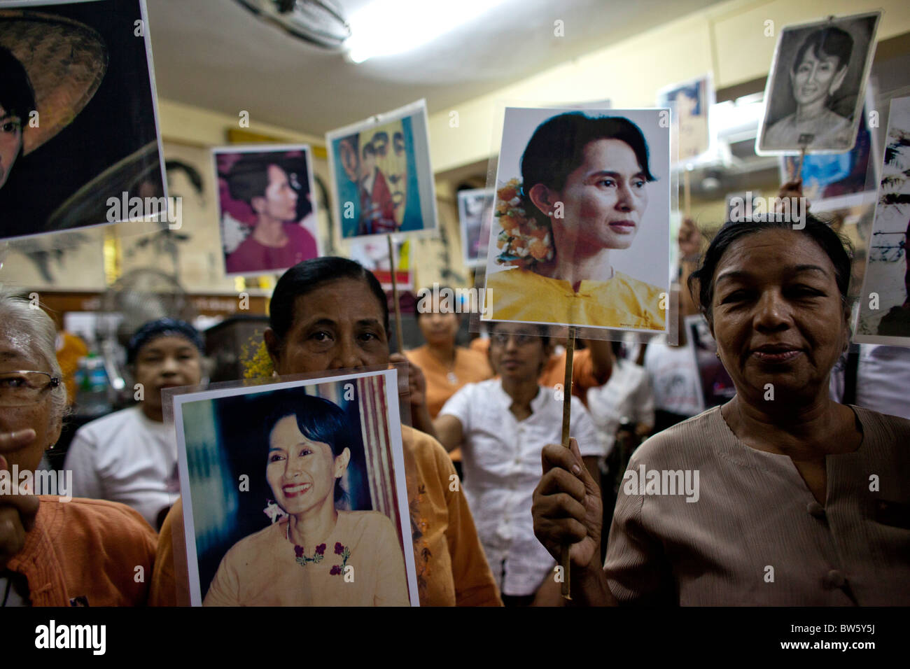 Unterstützer von Aung San Suu Kyi halten ihre Porträts, wie sie in der Nationalliga für Demokratie (NLD) Hauptsitz sammeln Stockfoto