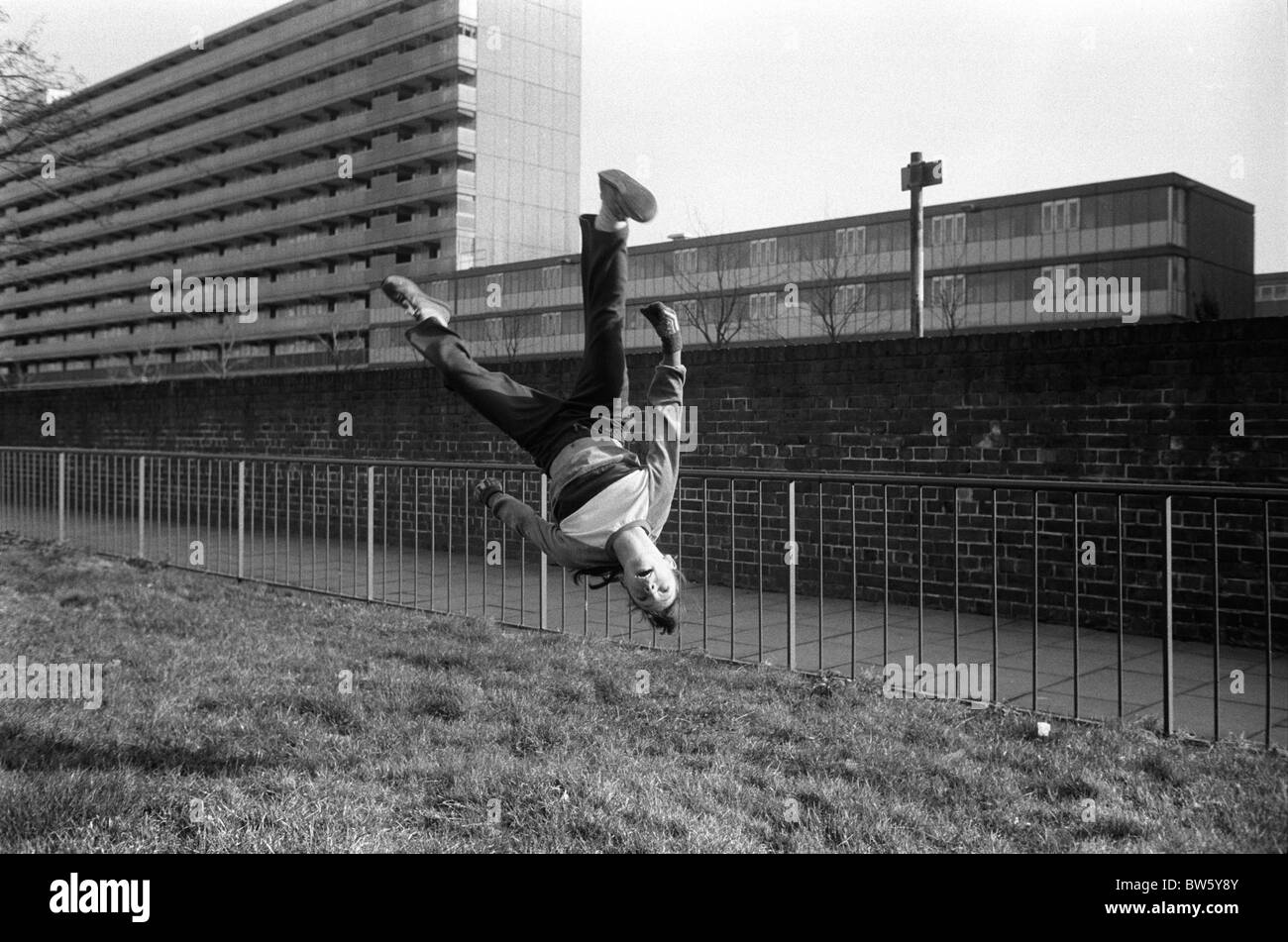 Teenager-Mädchen spielt in Street 1980s UK. Sie übt Gymnastik und macht einen Somersault. Heygate Estate, Walworth South London 1983 HOMER SYKES Stockfoto