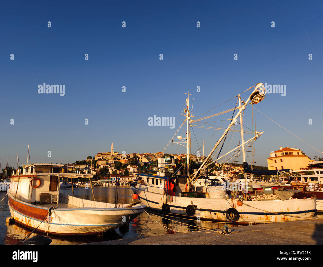 Angelboote/Fischerboote in Adria. Hafen von Vrsar, Altstadt in Kroatien, beliebtes Touristenziel. Abendlicht. Stockfoto