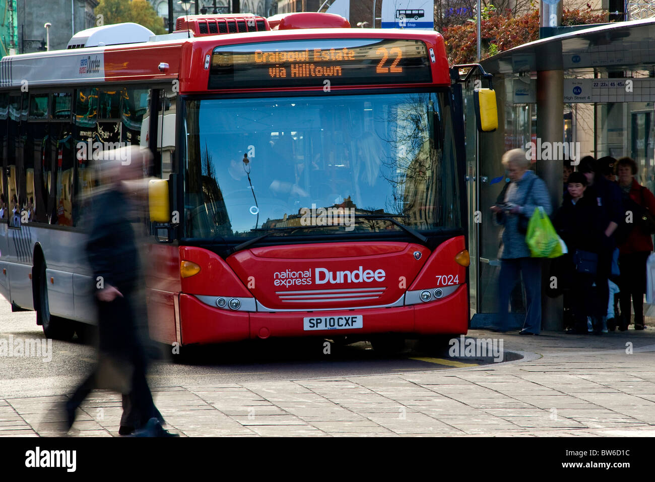 Bewegungsunschärfe von Menschen Schlange stehen an der Bushaltestelle und einsteigen in einen einzigen Doppeldecker-Bus in Dundee Stadtzentrum, UK Stockfoto