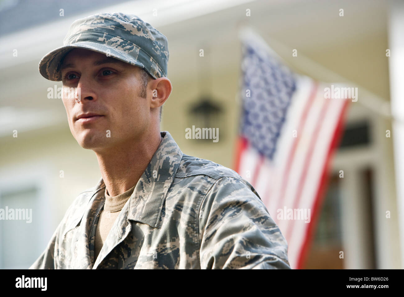 Mid-Adult Mann in Militäruniform, amerikanische Flagge im Hintergrund Stockfoto