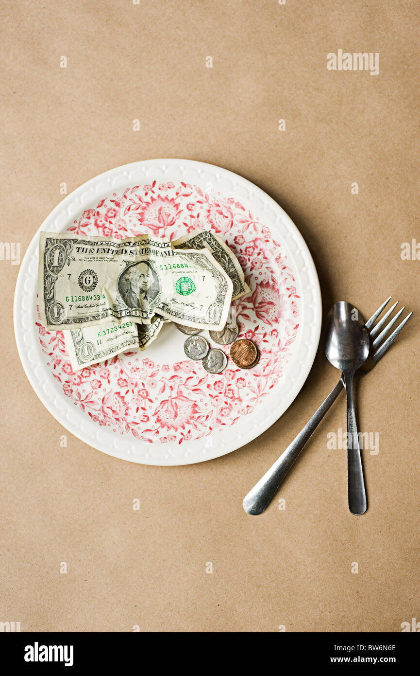 Konzeptuelles Bild von Bargeld auf einem Teller, das „Billige Speisen“ bedeutet Stockfoto