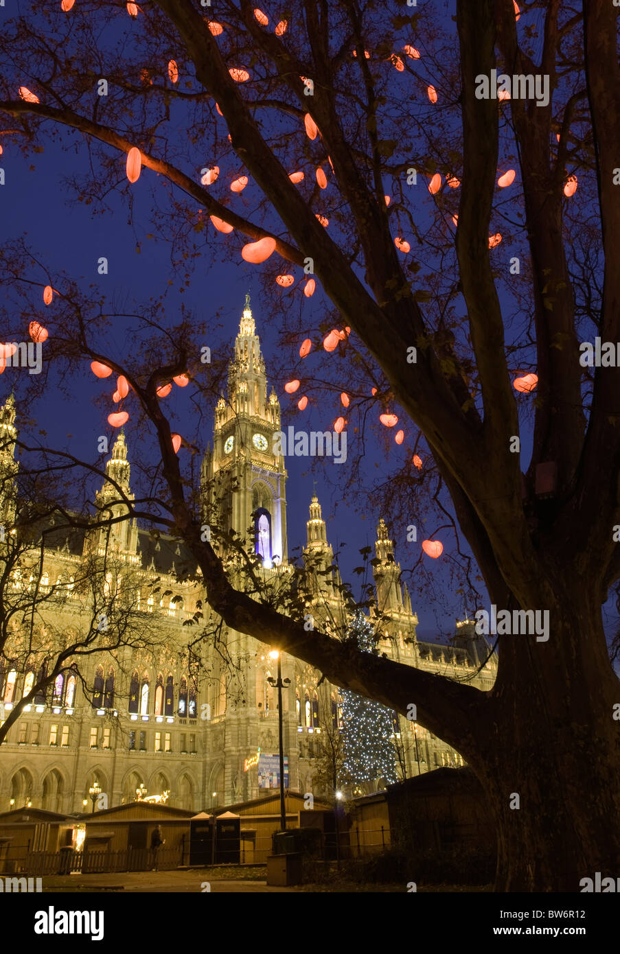 Die Bäume, die das beleuchtete Rathaus Rathausplatz, Vienna umgeben sind während der Weihnachtszeit geschmückt. Stockfoto