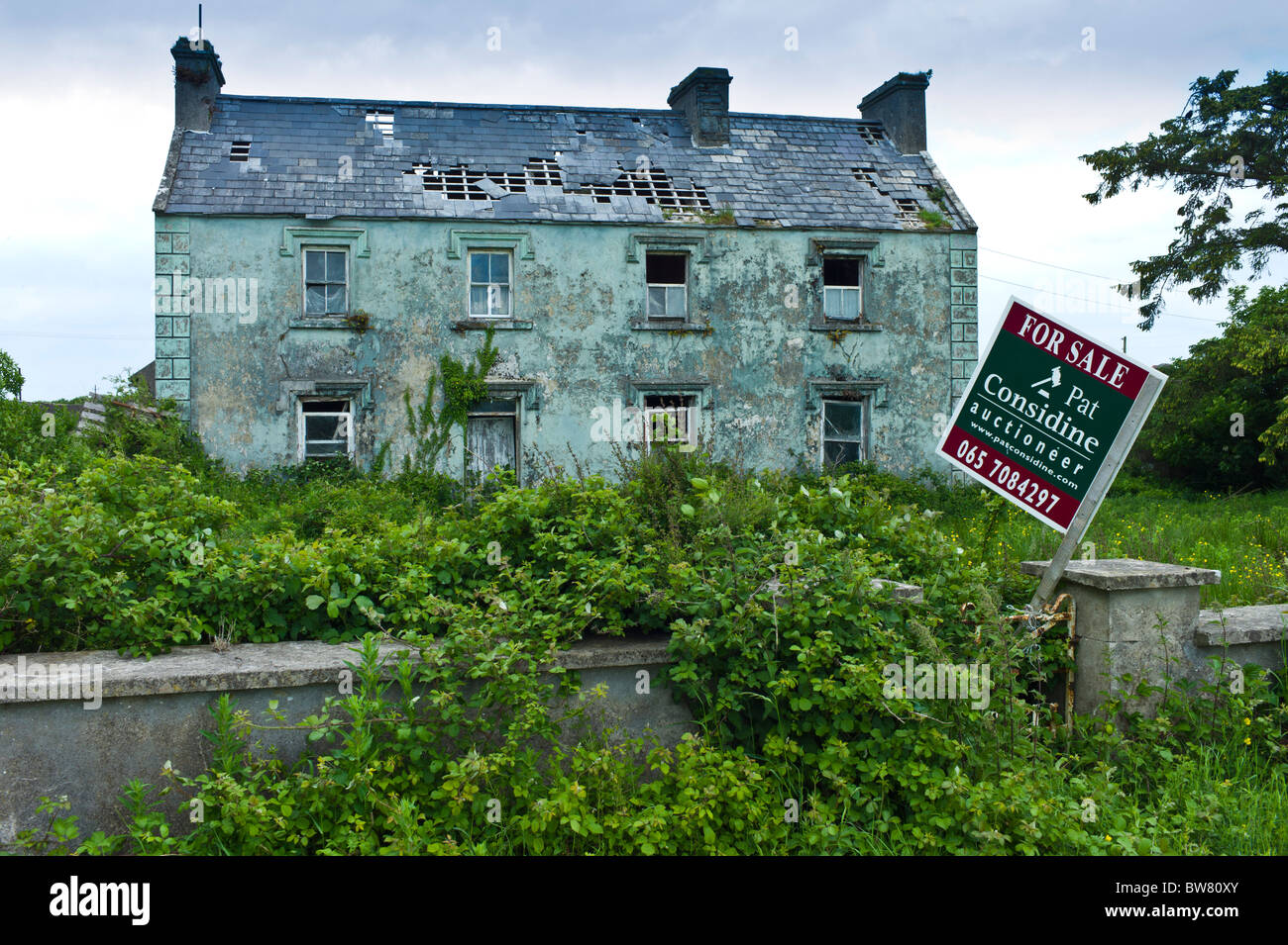Verfallenes Haus mit für Verkauf Makler Auktionator Board in Moyasta, County Clare, Irland Stockfoto