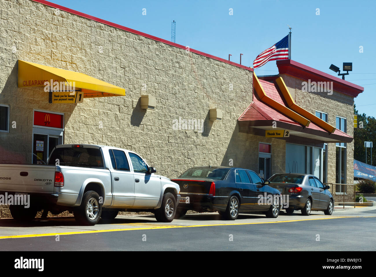 Drei Autos warten in der Schlange vor einem McDonalds Drive-Thru an einem klaren Herbsttag in South Carolina, USA. Stockfoto