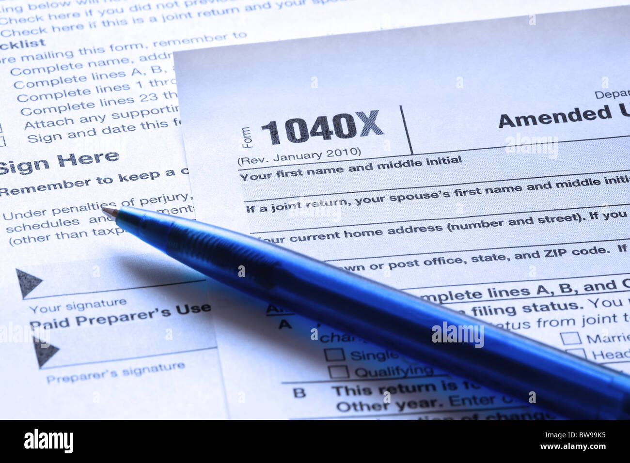 Blau getönten US Einkommenssteuer Form 1040 X und einem blauen Stift Nahaufnahme. Flachen DOF. Stockfoto