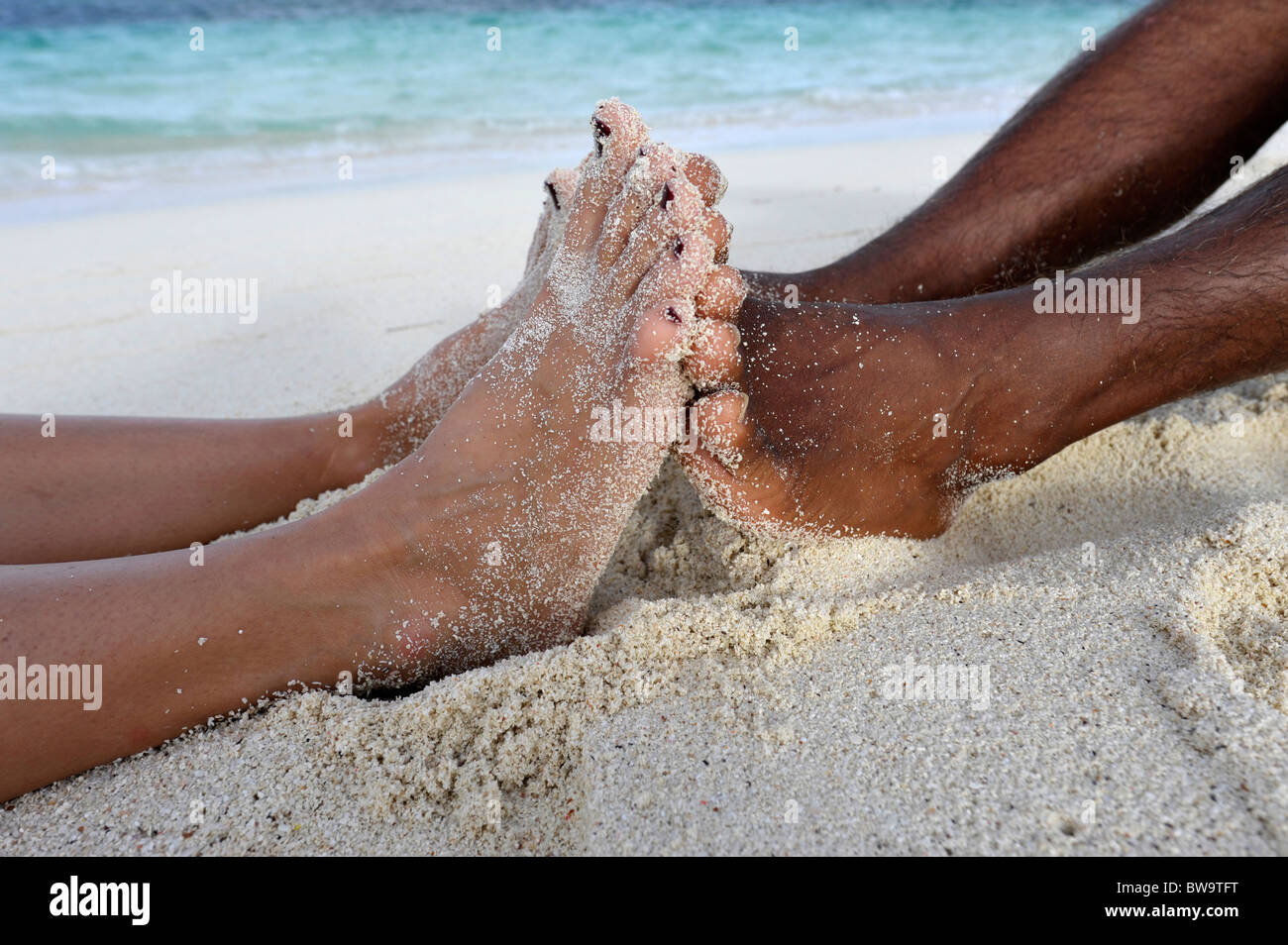 Nahaufnahme der Füße eines dunklen enthäuteten Paares, Desroches Island, Seychellen Stockfoto