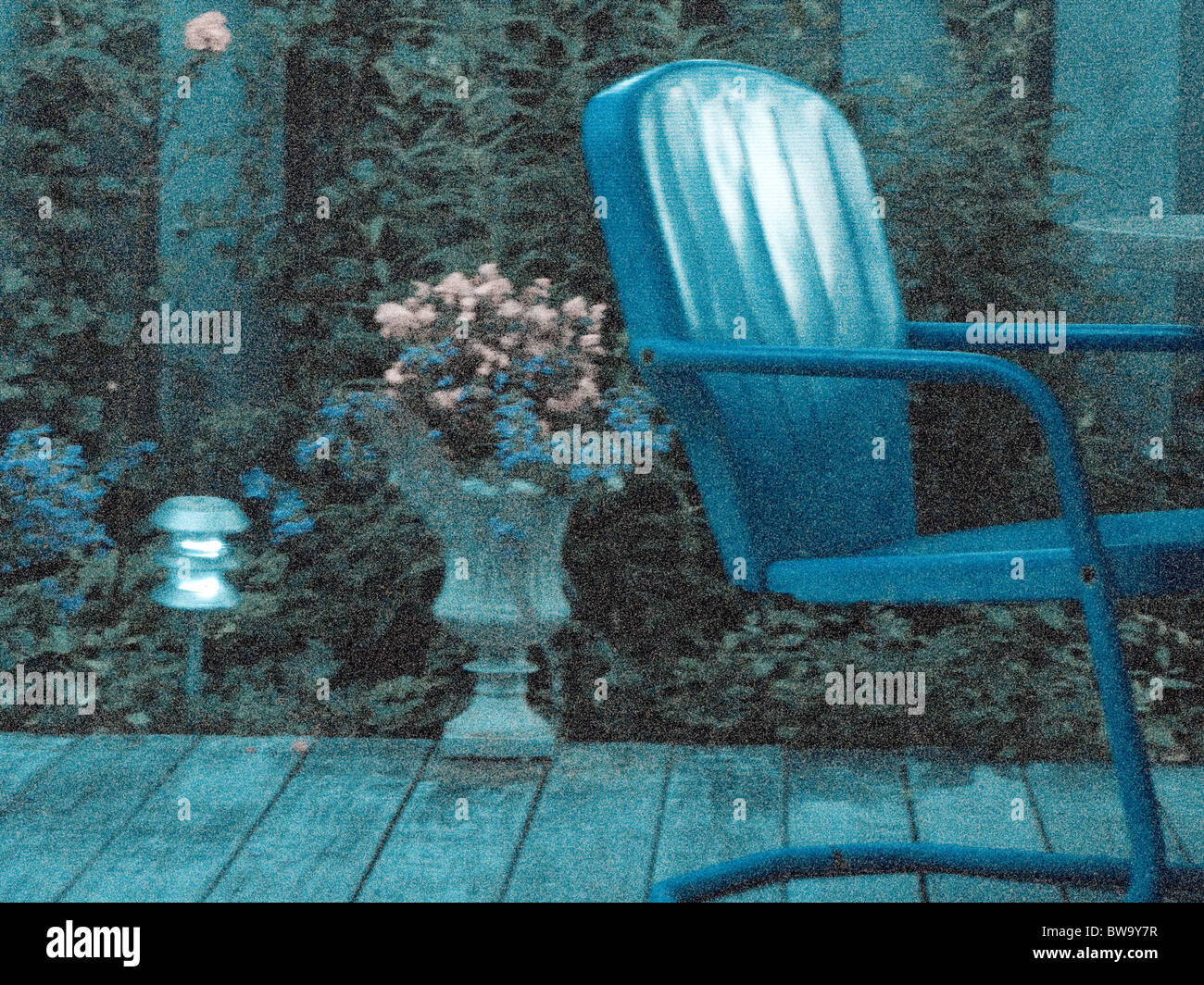 körnige Schuss Blau von alten Stuhl mit Blumen auf Holzdeck. Stockfoto