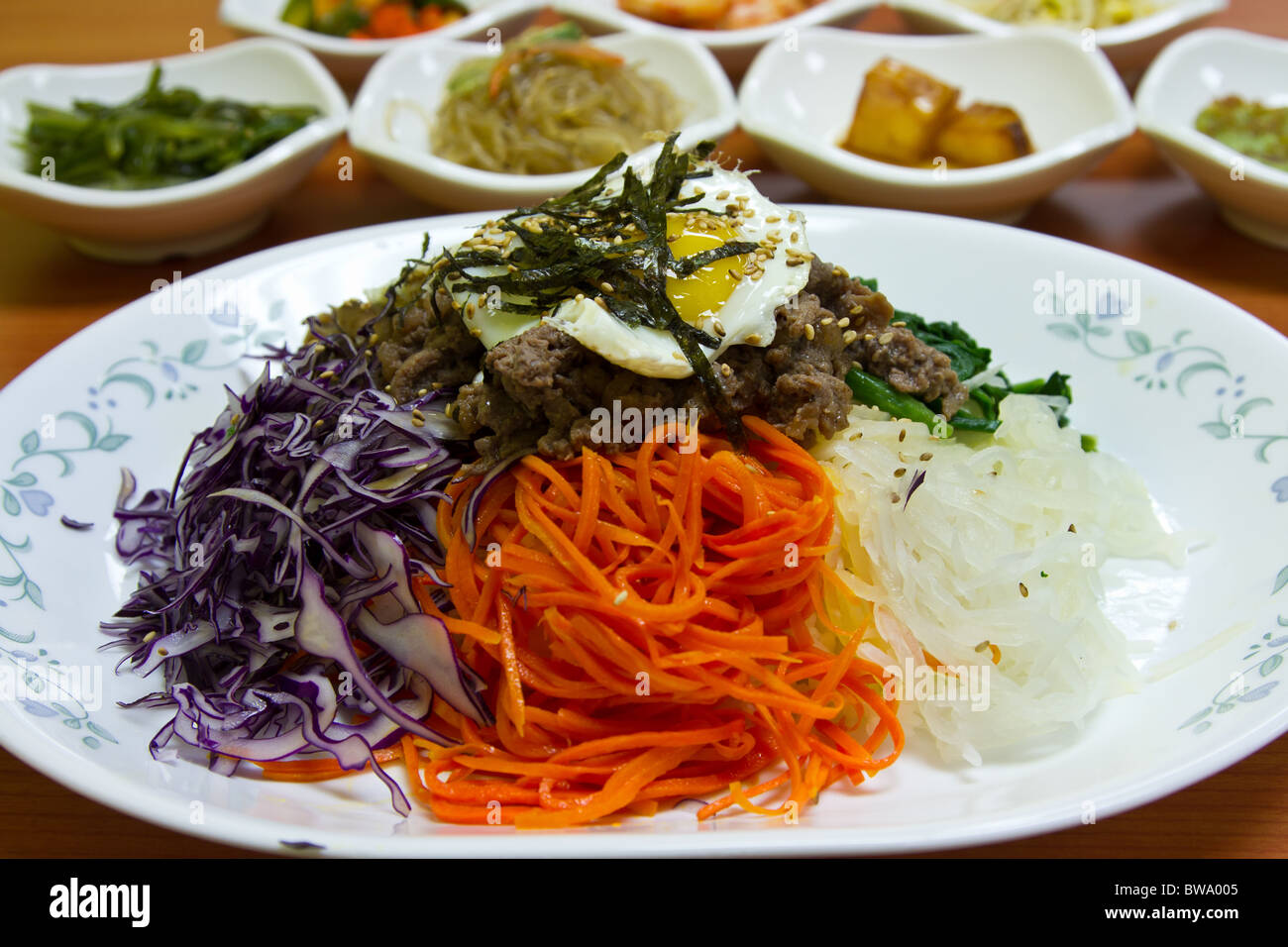 Ein beliebtes koreanisches Gericht Bibimbap, mittlere Mischung Reis garniert mit gewürztes Gemüse, Paprika, Spiegelei und Rindfleisch in Scheiben Stockfoto Ein beliebtes koreanisches Gericht Bibimbap, mittlere Mischung Reis garniert mit gewürztes Gemüse, Paprika, Spiegelei und Rindfleisch in Scheiben Stockfoto