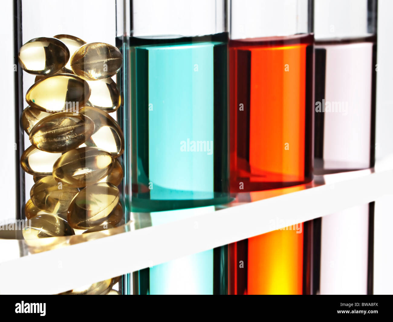 Reihe der Reagenzgläser gefüllt mit farbigen Flüssigkeit, eine gefüllt mit Gel GAP Vitamine. Stockfoto
