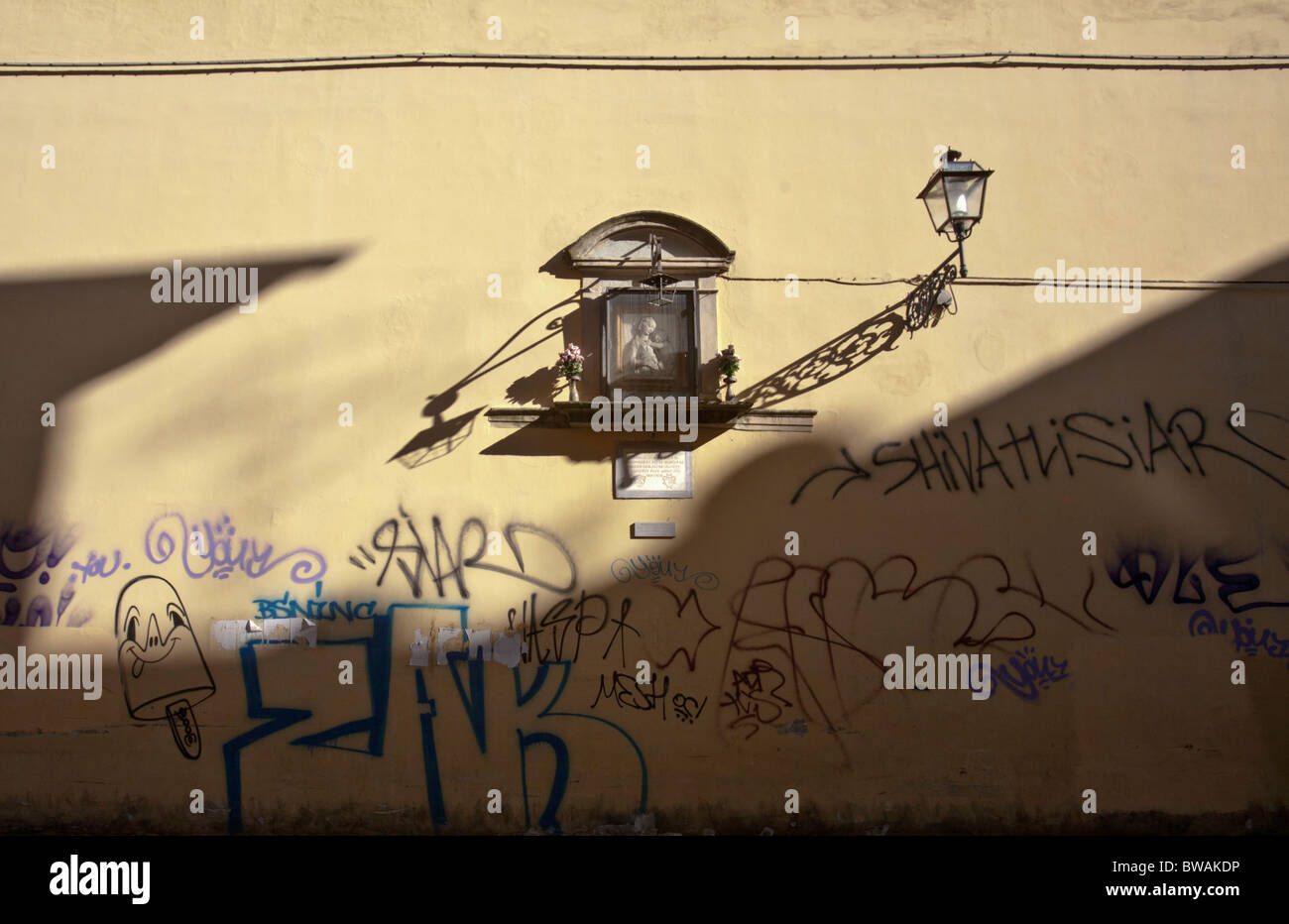 Seltsames nebeneinander am Straßenrand Schrein, eine aufwändig verzierte Straßenlaterne und graffiti Stockfoto