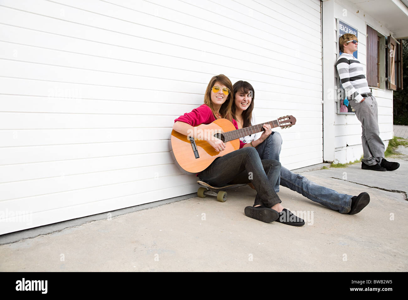 Zwei Mädchen sitzen auf Boden mit Gitarre Stockfoto