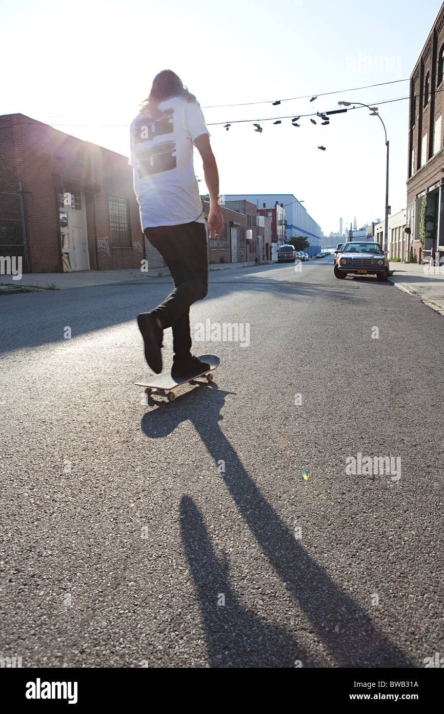 Skateboarder in städtischen Straße im Sonnenlicht Stockfoto