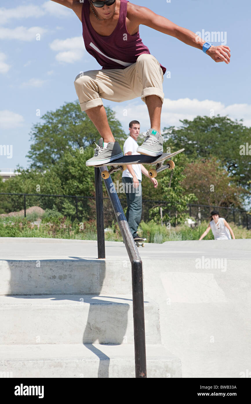 Skateboarder über Geländer springen Stockfoto