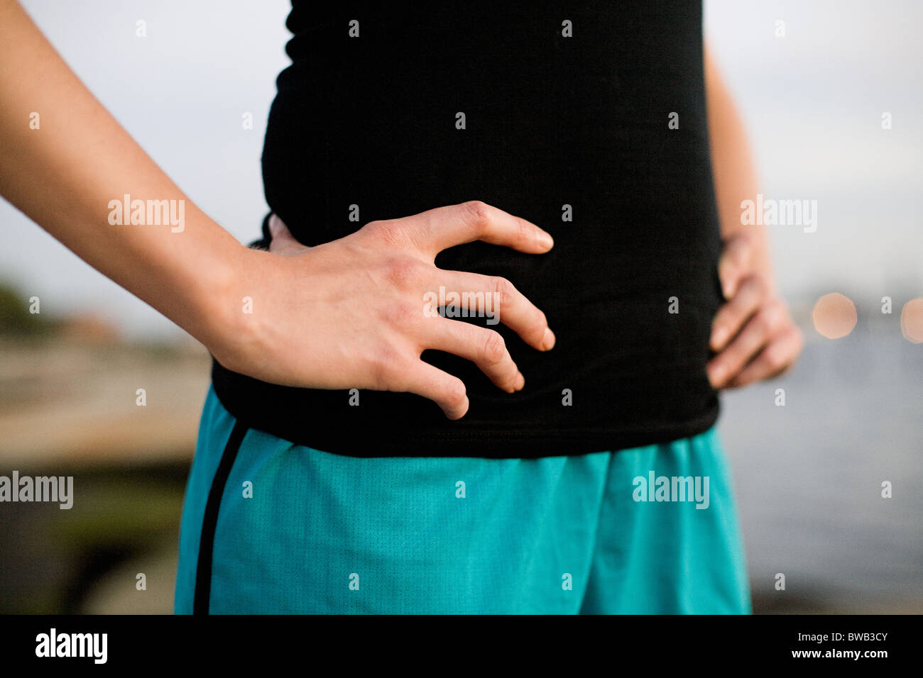 Läufer mit Hände auf den Hüften in enger Stockfoto
