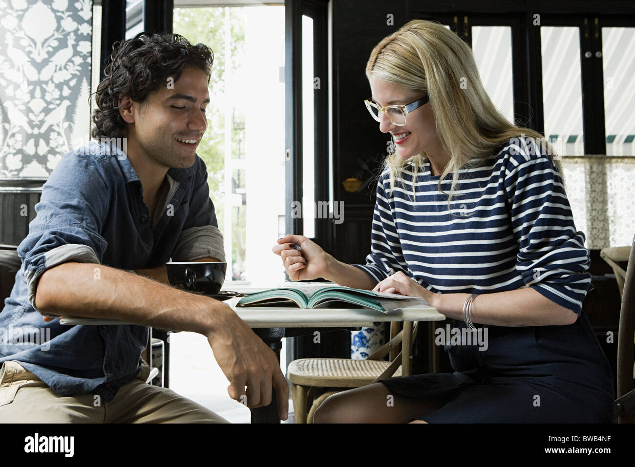 Mann mit Handy und Frau mit Laptop im café Stockfoto