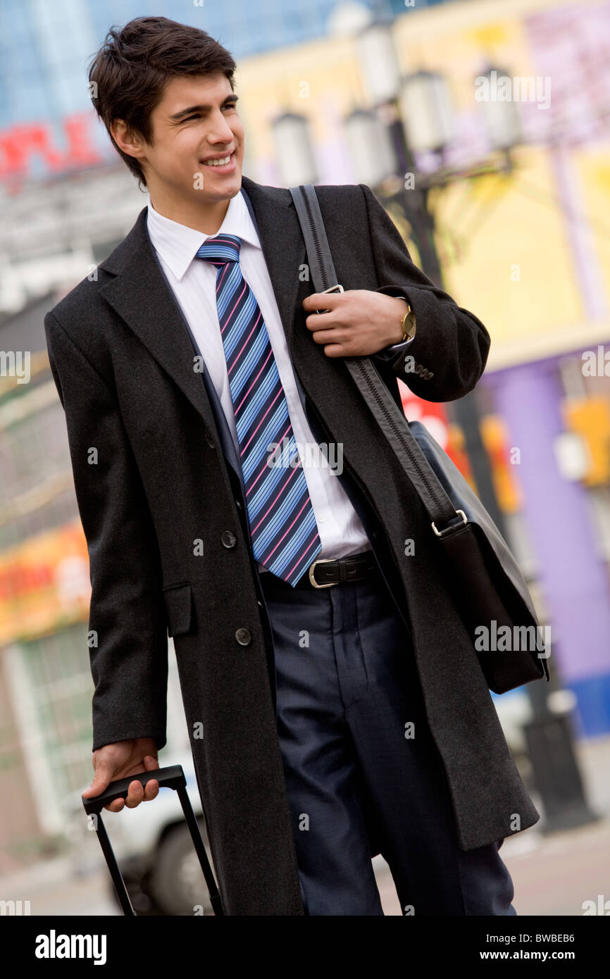 Porträt des erfolgreichen Unternehmers hinunter die zentrale Straße von Großstadt und schaut sich um Stockfoto