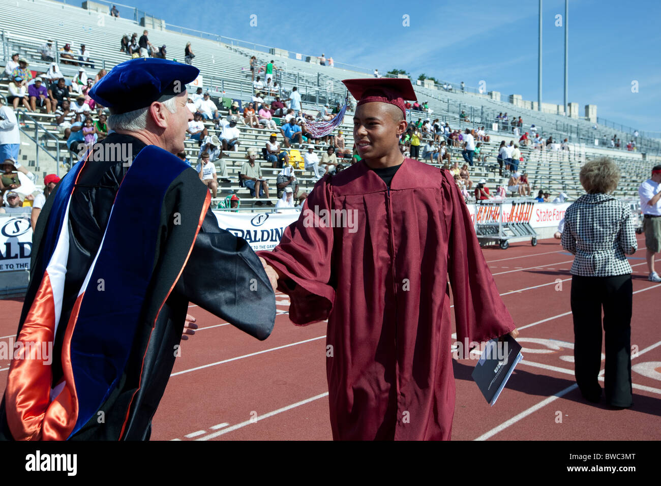 Afro-amerikanische Student erhält Abitur von der Schule offizielle während Outdoor-Abschlussfeier Stockfoto
