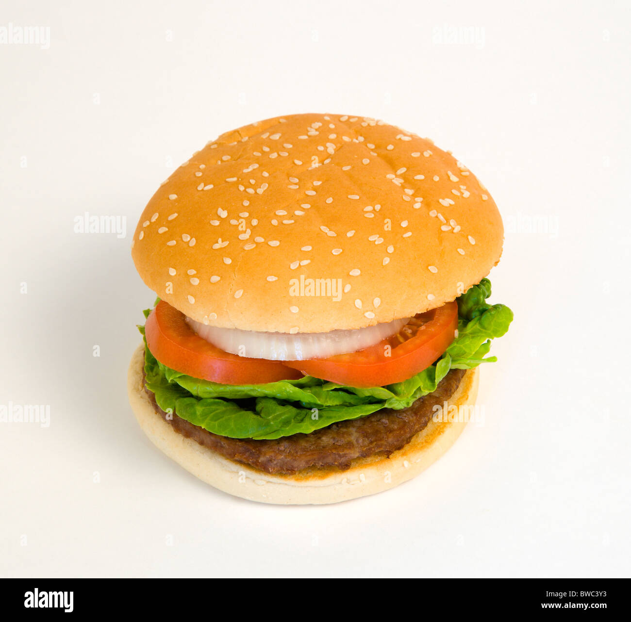Essen, gekocht, Hamburger, einzelne Viertel-Pfund-Burger mit Zwiebel-Tomaten-Salat in ein Brötchen auf einem weißen Hintergrund. Stockfoto