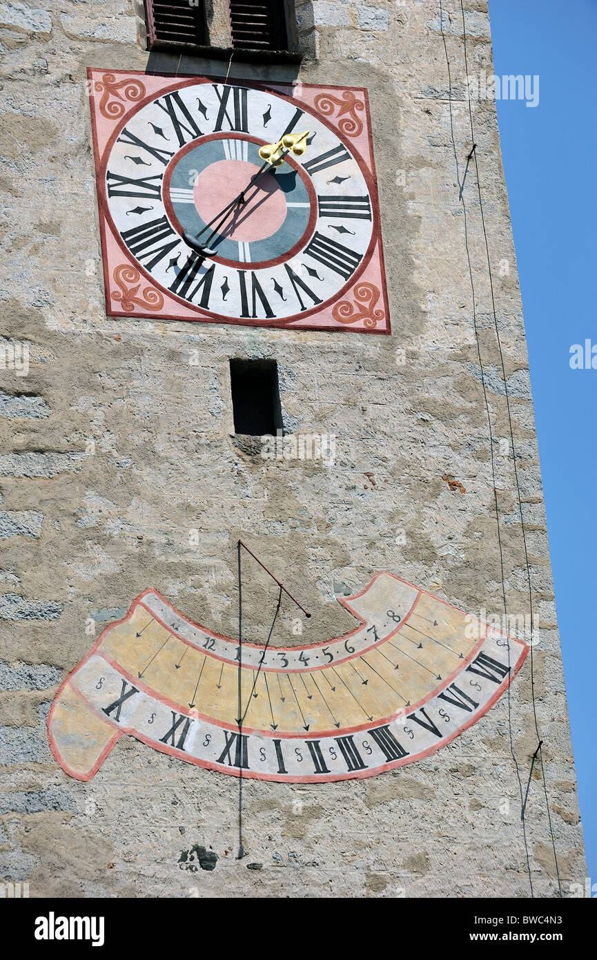 Uhr und Sonnenuhr am Kirchturm in Chiusa / Klausen, Dolomiten, Italien Stockfoto