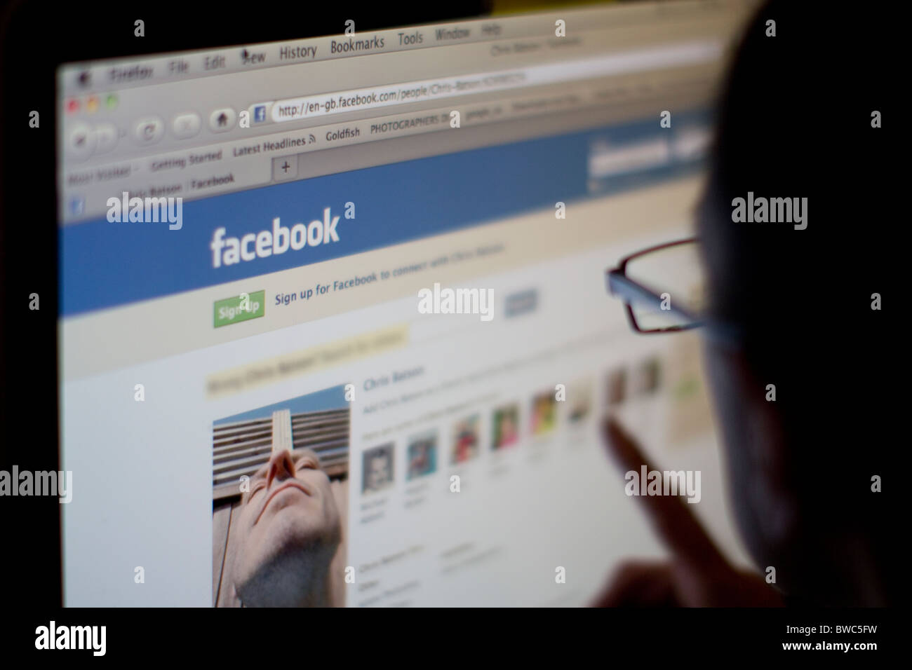 Männlich, der auf den Bildschirm der Website des sozialen Netzwerks Facebook blickt Stockfoto