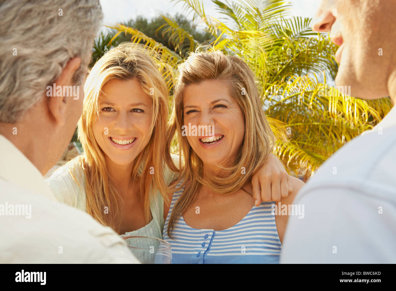 Mutter und Tochter im Gespräch mit zwei Männer Stockfoto