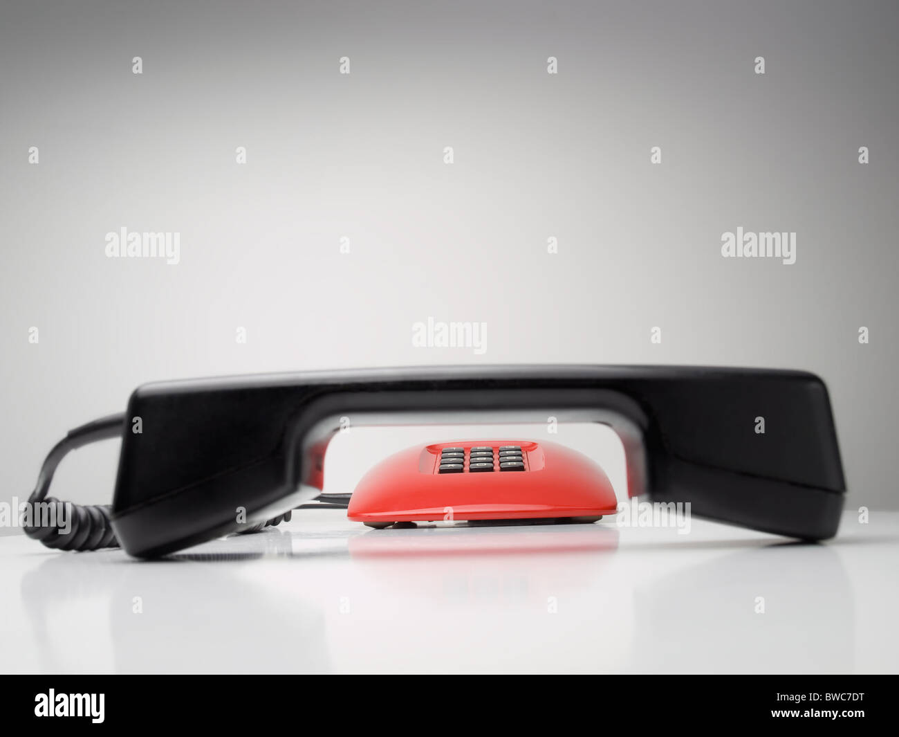 rotes Telefon mit Fokus auf die Zifferblatt-Tasten im Hintergrund, für Kommunikation, Notfall oder Service-Themen Stockfoto