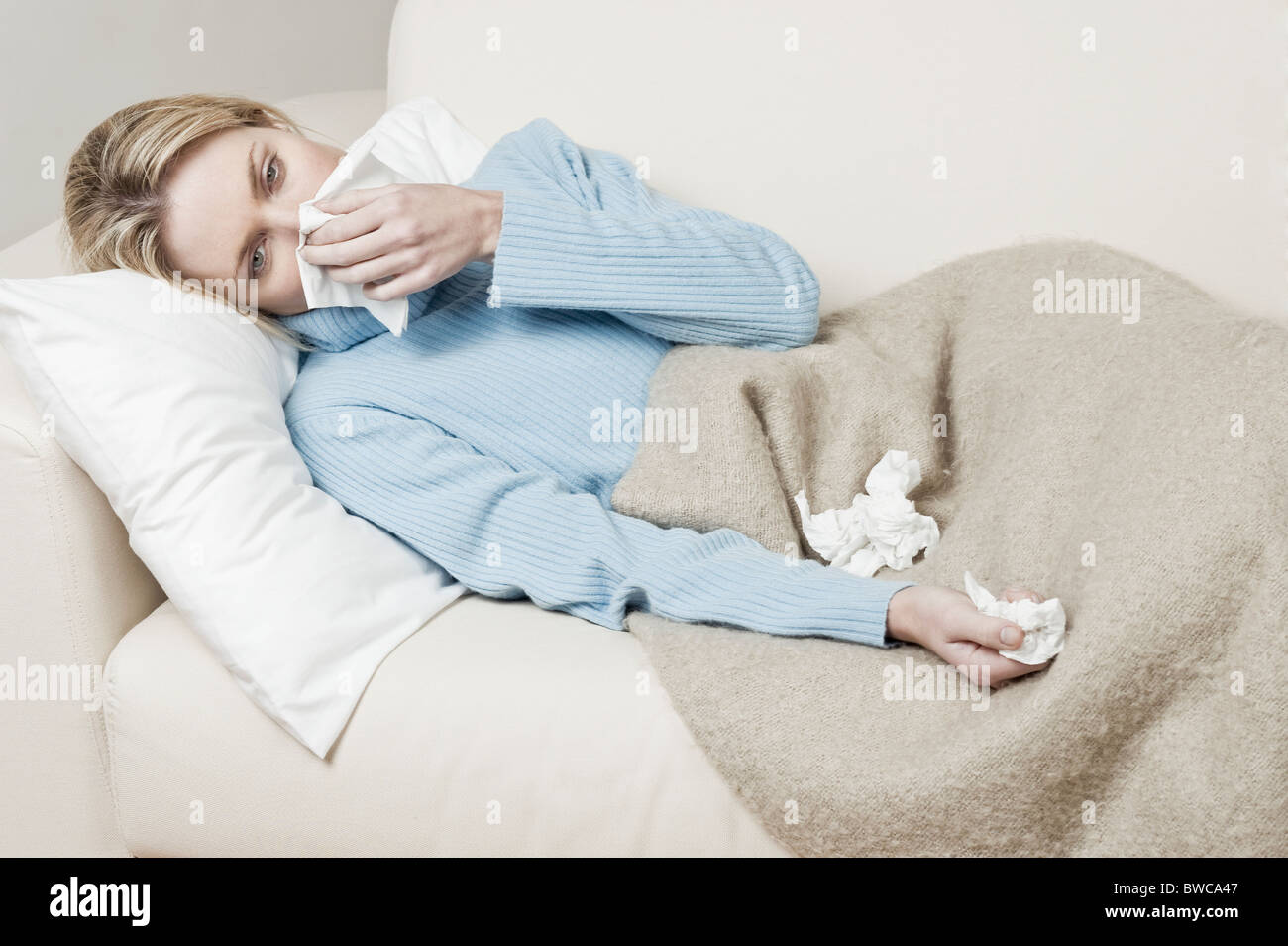 Südafrika, Cape Town, junge Frau auf dem Sofa liegend und Nase weht Stockfoto