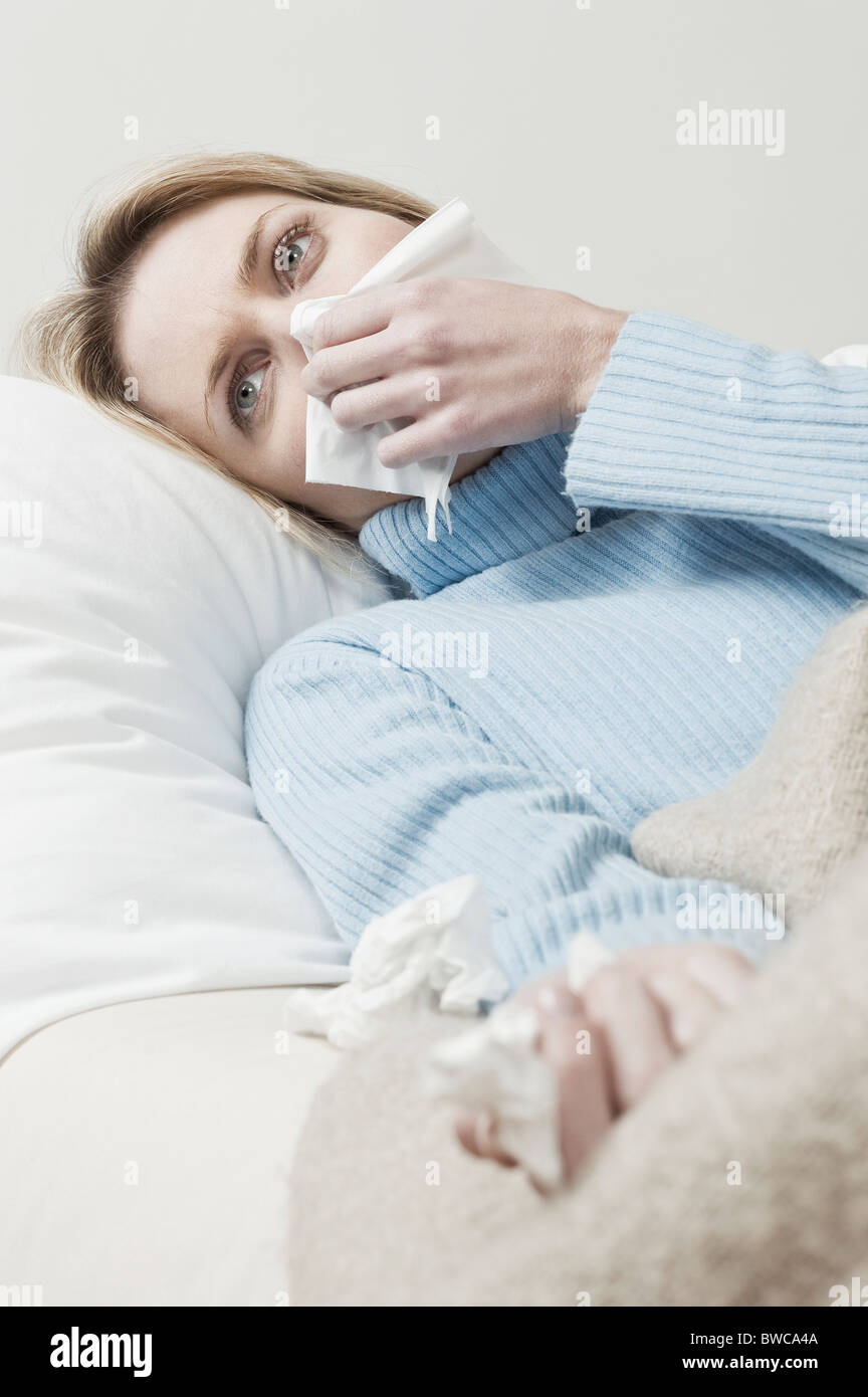 Südafrika, Cape Town, junge Frau auf dem Sofa liegend und Nase weht Stockfoto