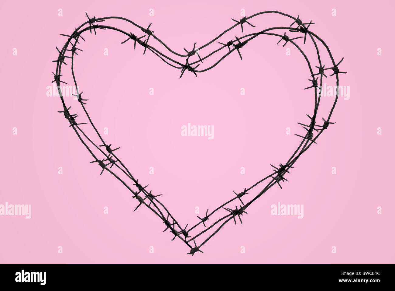 Foto des großen eisernen Herzens über rosa Hintergrund Stockfoto