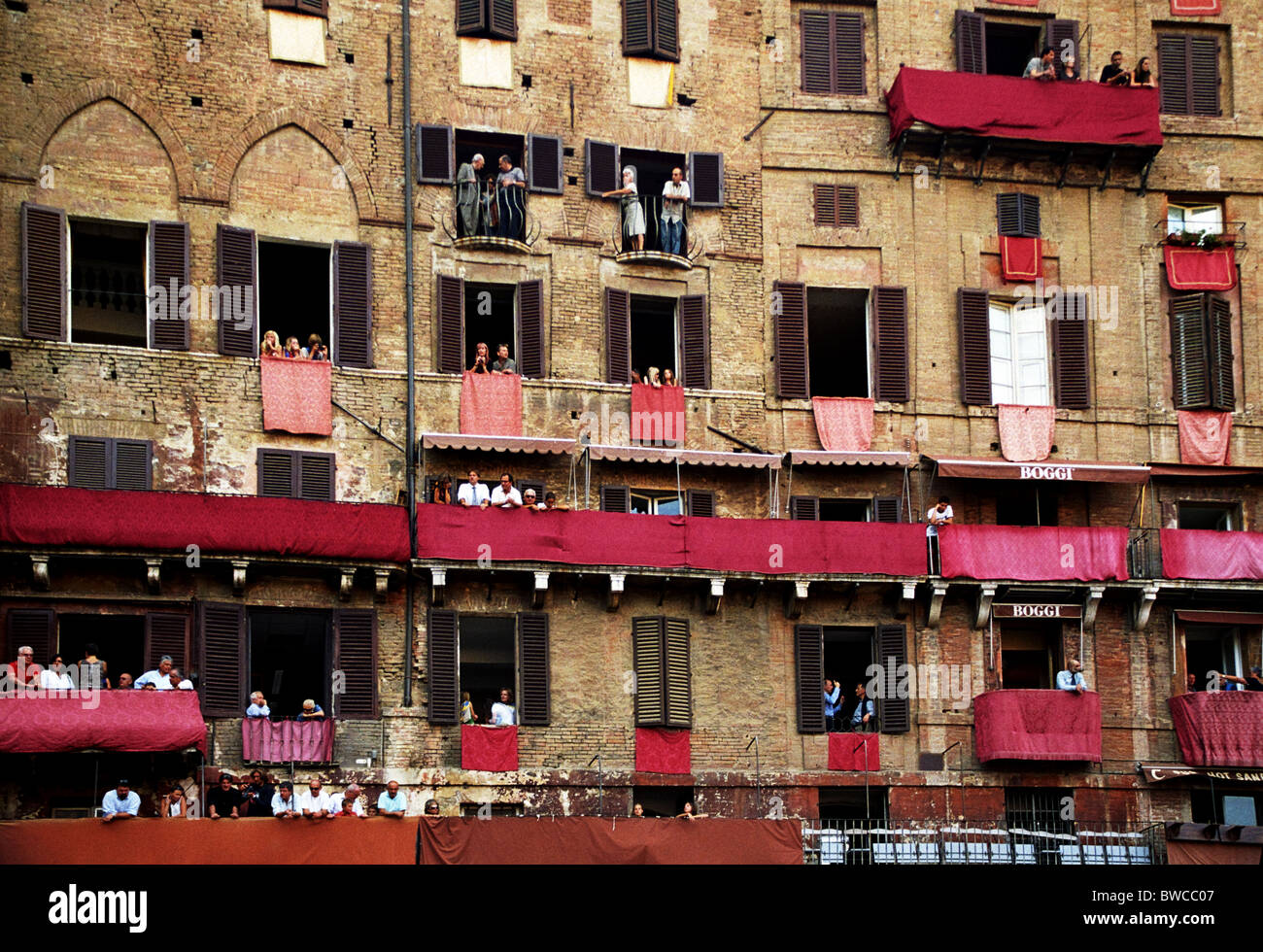 Reden auf dem Balkon beobachten das Palio-Pferderennen in Siena, Italien. Stockfoto