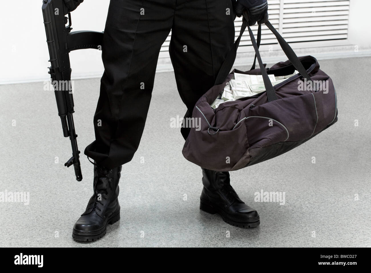 Bild der Beine der Einbrecher mit Tasche voll mit gestohlenem Geld in der hand Stockfoto
