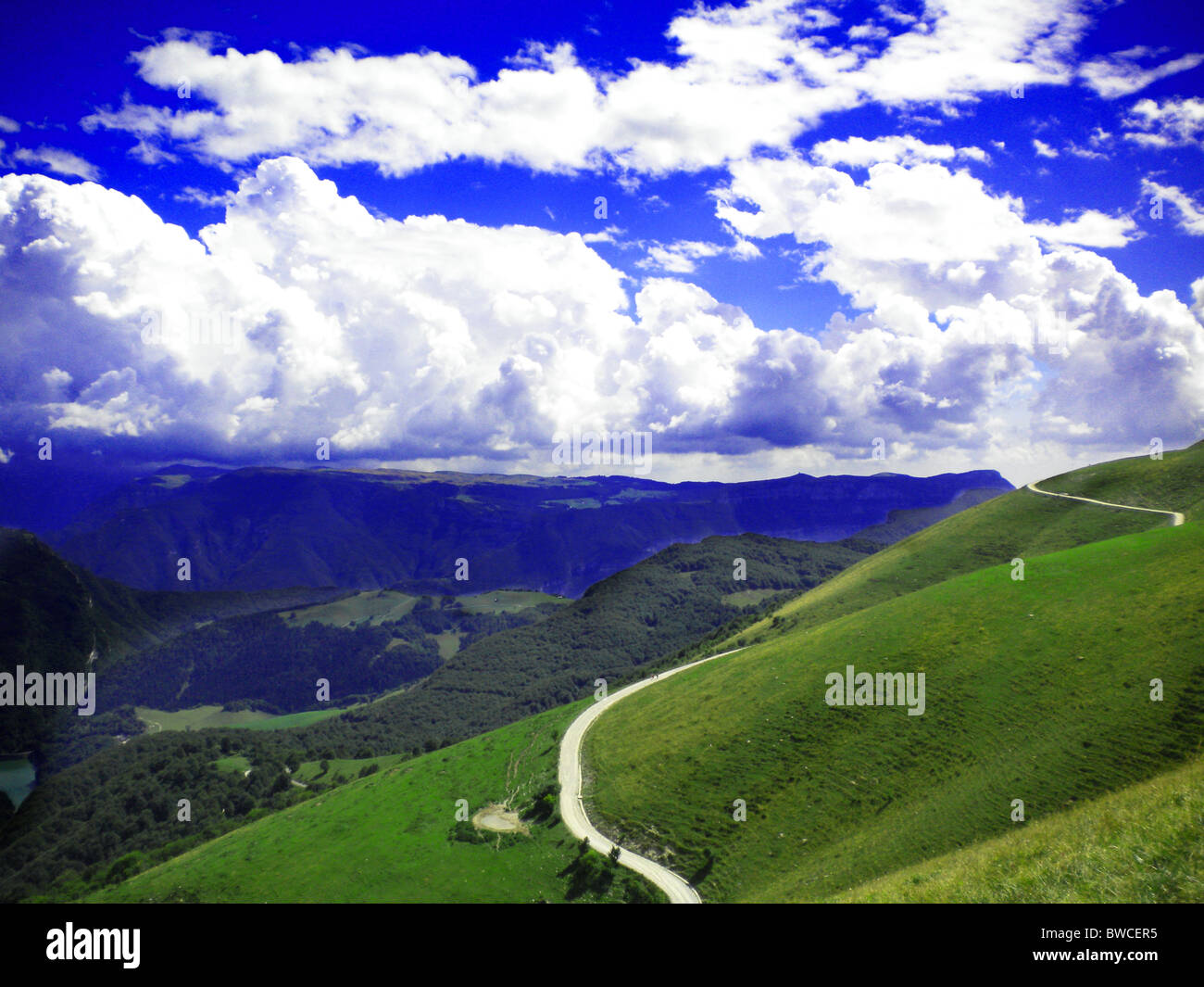 Berglandschaft mit grünen Wiesen und blauem Himmel mit Wolken Stockfoto
