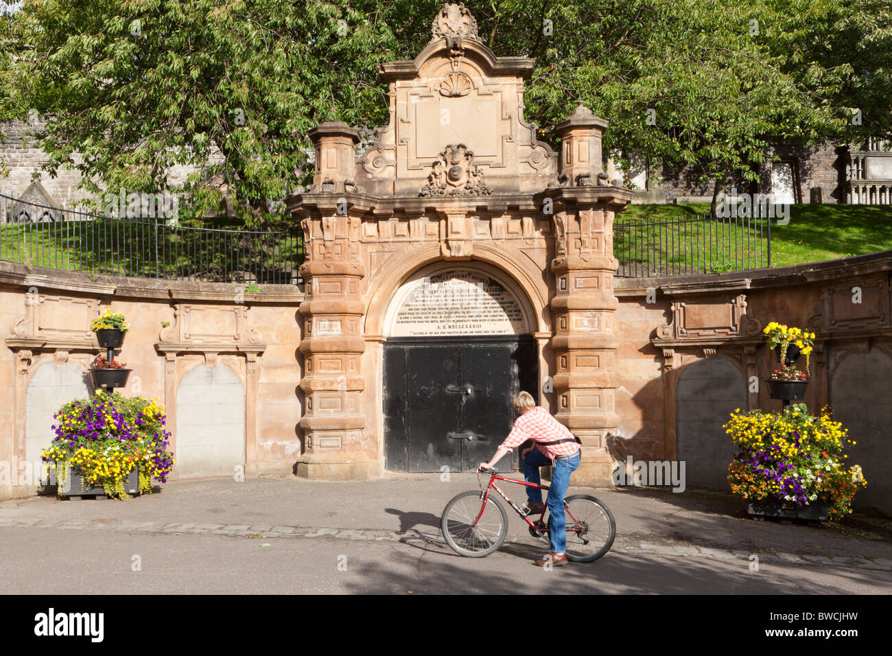 Ein Radfahrer, den Eingang zu den Glasgow Necropolis liegt östlich von Glasgow Cathedral, Schottland zu bewundern Stockfoto