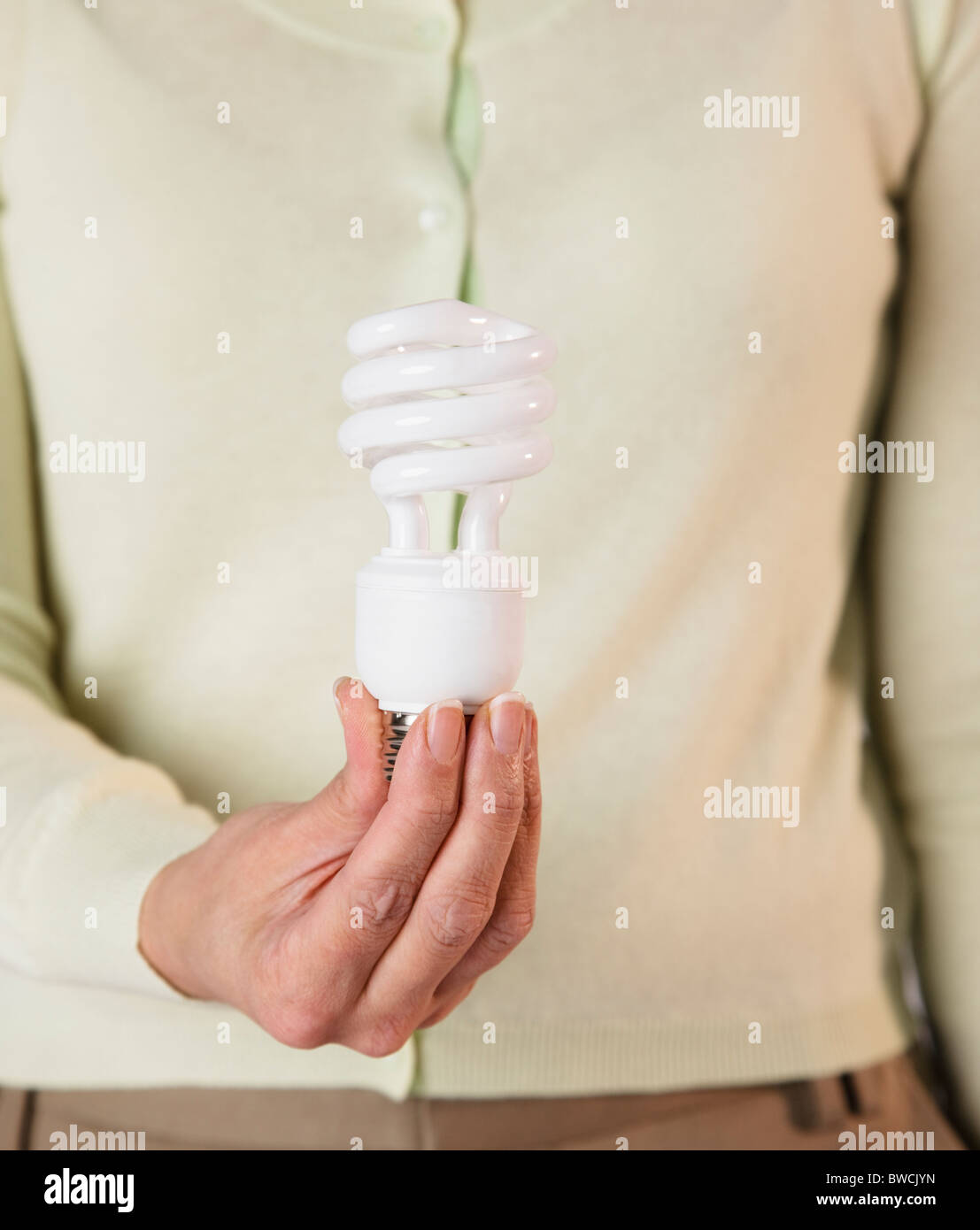 USA, Illinois, Metamora, Frau Holding energiesparende Glühbirne, Mittelteil Stockfoto