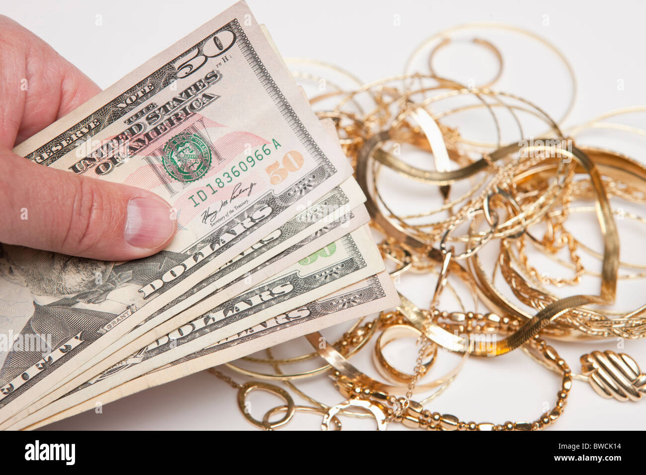 Hand, die Fan von fünfzig-Dollar-Scheine gegen Goldschmuck Stockfoto