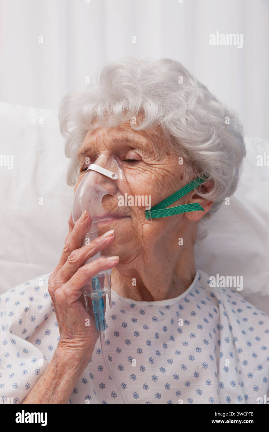 USA, Illinois, Metamora, Senior Frau mit Sauerstoffmaske im Krankenhausbett liegen Stockfoto